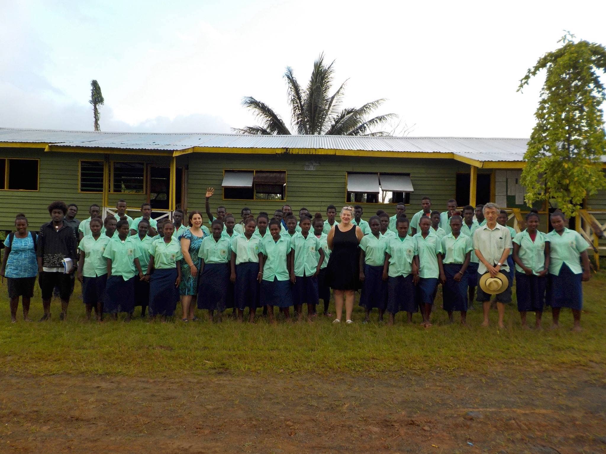 A class photo with school building in the background
